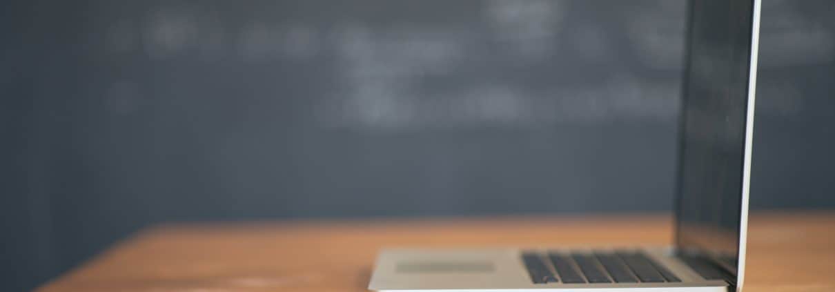 a budding real estate professional prepares his first written resume along side an Apple laptop