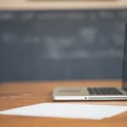 a budding real estate professional prepares his first written resume along side an Apple laptop